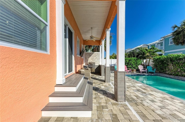 exterior space featuring ceiling fan and a fenced in pool