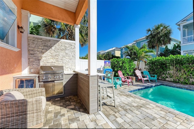 view of swimming pool with a bar, an outdoor kitchen, grilling area, and a patio