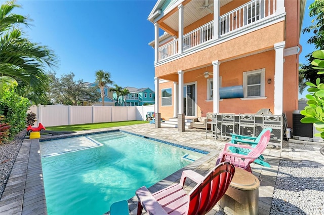 view of swimming pool with ceiling fan and a patio