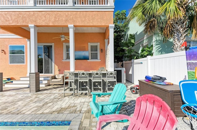 view of patio / terrace with ceiling fan and a balcony