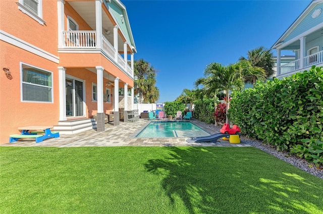 view of swimming pool featuring a lawn and a patio