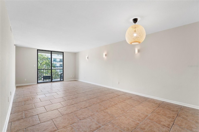 empty room featuring floor to ceiling windows and light tile patterned floors