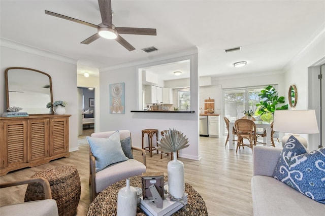 living room featuring ceiling fan, ornamental molding, and light hardwood / wood-style flooring