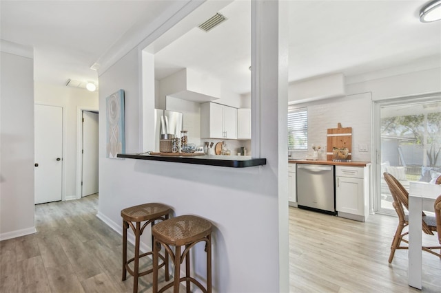 kitchen featuring stainless steel appliances, white cabinetry, light wood-type flooring, and kitchen peninsula