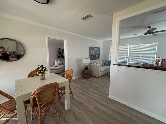 dining area featuring hardwood / wood-style floors, ornamental molding, and ceiling fan