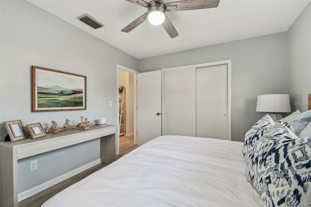 bedroom with dark wood-type flooring, a closet, and ceiling fan