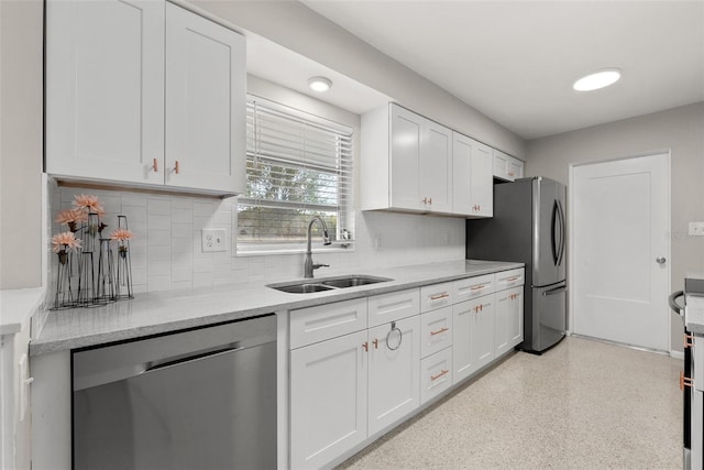 kitchen featuring tasteful backsplash, appliances with stainless steel finishes, sink, and white cabinets