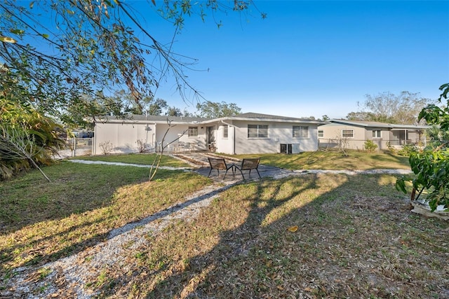 view of front of home featuring cooling unit and a front lawn