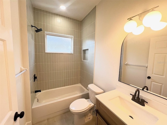 full bathroom featuring tile patterned flooring, tiled shower / bath, vanity, and toilet