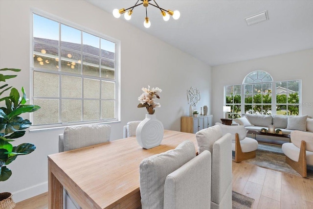 dining area featuring light hardwood / wood-style floors and a chandelier