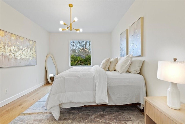 bedroom featuring an inviting chandelier and wood-type flooring