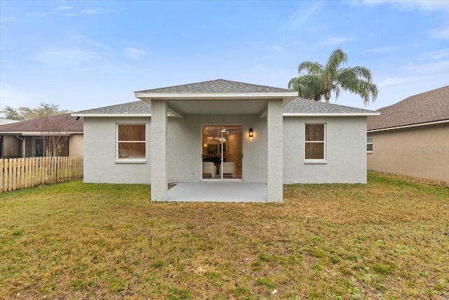 rear view of property featuring a yard and a patio area