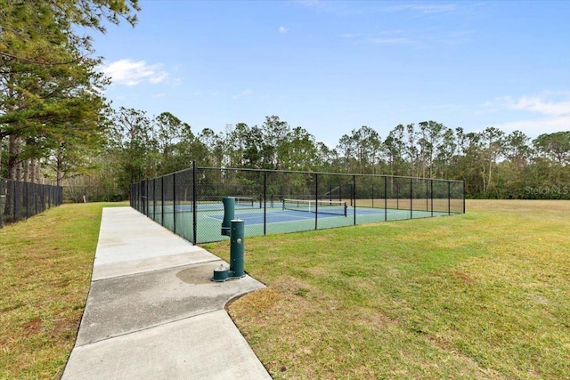 view of tennis court with a lawn