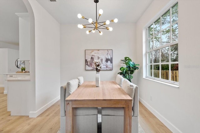 dining space with a chandelier and light wood-type flooring