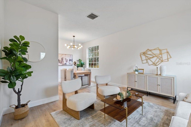 living area with wood-type flooring and a notable chandelier