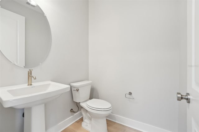 bathroom with sink, toilet, and wood-type flooring