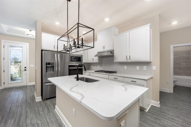 kitchen featuring stainless steel appliances, sink, a center island with sink, and white cabinets