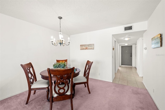 dining space with light colored carpet, a chandelier, and a textured ceiling