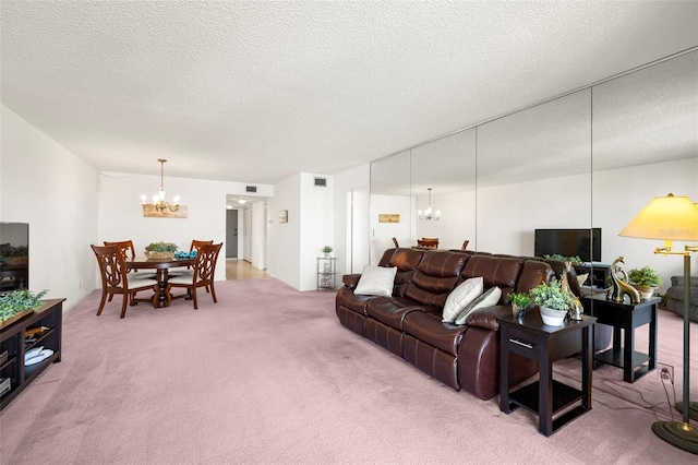 living room with a notable chandelier, a textured ceiling, and carpet