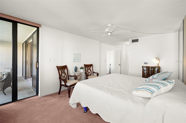 carpeted bedroom featuring ceiling fan and a textured ceiling