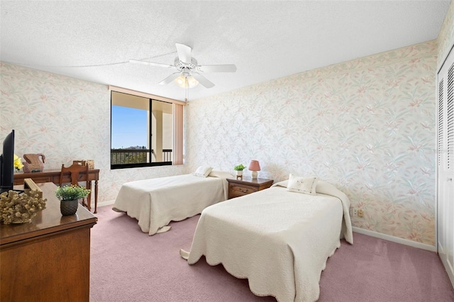 carpeted bedroom featuring ceiling fan and a textured ceiling