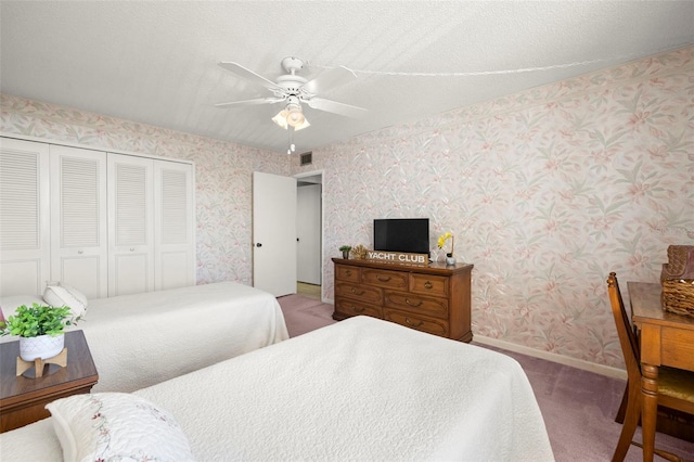 bedroom with carpet floors, a textured ceiling, ceiling fan, and a closet