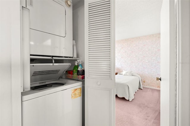 washroom with stacked washer and clothes dryer and carpet