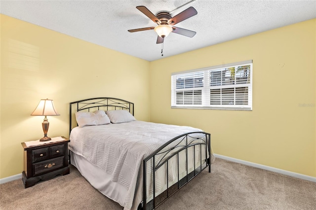 bedroom with ceiling fan, light carpet, and a textured ceiling