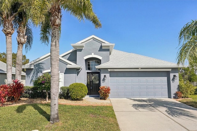 view of front of house featuring a garage and a front lawn