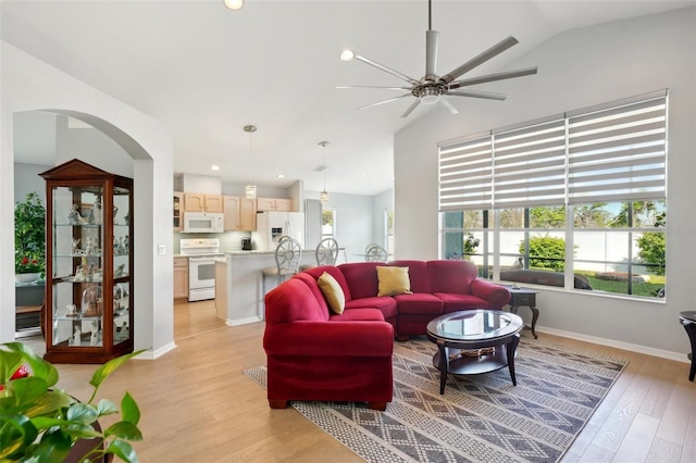 living room featuring vaulted ceiling, light hardwood / wood-style floors, and ceiling fan