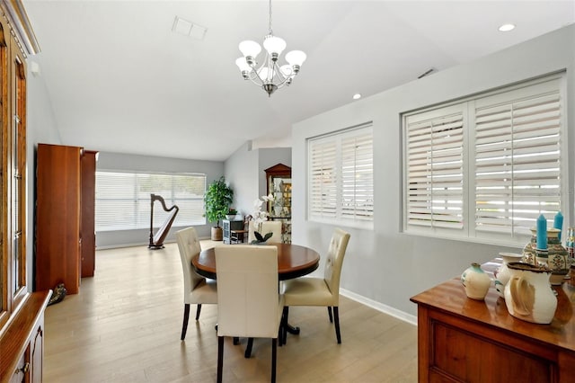 dining space featuring vaulted ceiling, a chandelier, and light hardwood / wood-style floors