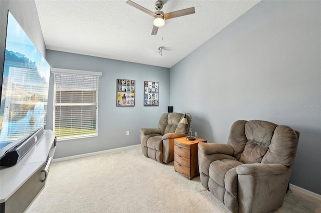 sitting room with light carpet, ceiling fan, and a textured ceiling