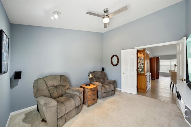 living area featuring light carpet and ceiling fan