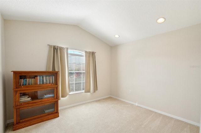 carpeted empty room with vaulted ceiling