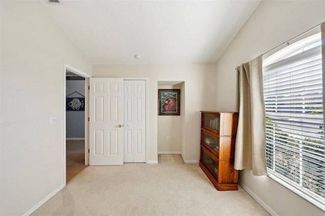 carpeted bedroom featuring lofted ceiling and a closet