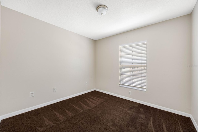 unfurnished room with a textured ceiling and carpet flooring