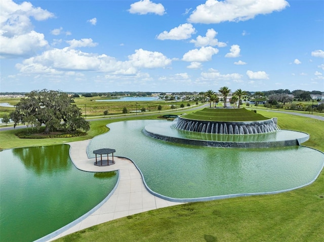 surrounding community with a water view and a lawn