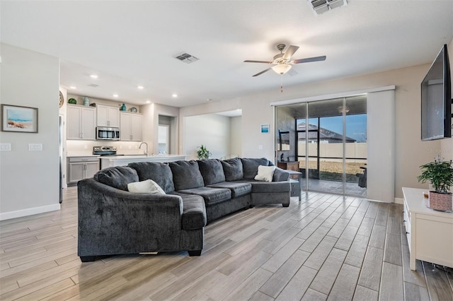 living room featuring ceiling fan and light wood-type flooring