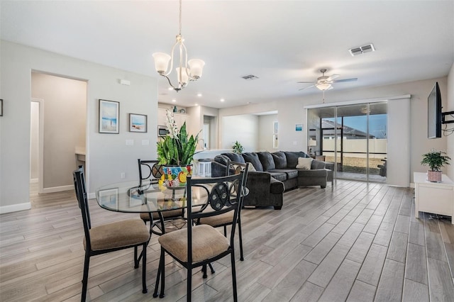 dining area featuring ceiling fan with notable chandelier and light wood-type flooring