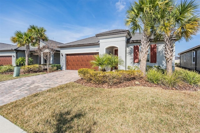 mediterranean / spanish home featuring a garage and a front lawn