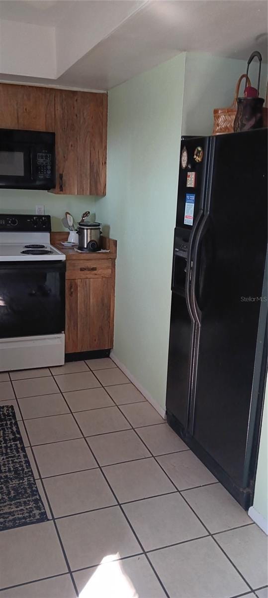 kitchen featuring light tile patterned floors and black appliances