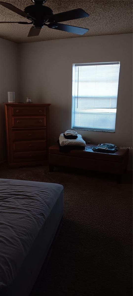 bedroom with ceiling fan and a textured ceiling