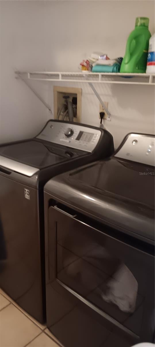 washroom featuring washer and clothes dryer and tile patterned flooring