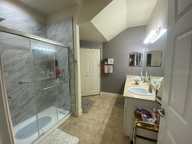 bathroom featuring vanity, vaulted ceiling, and a shower with door