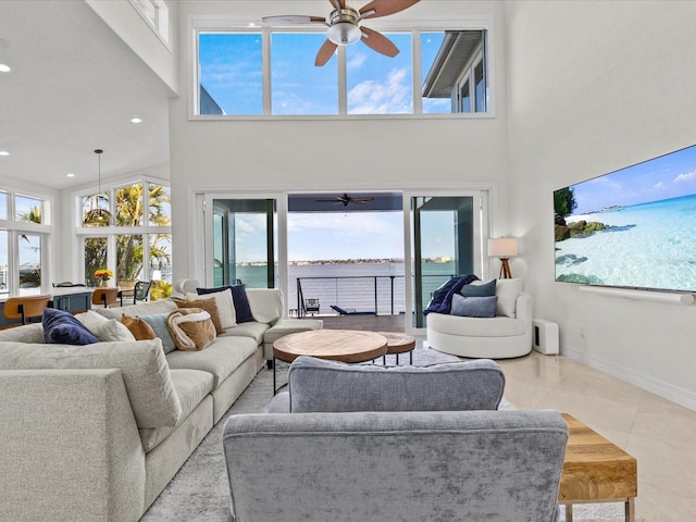 living room featuring a high ceiling, light tile patterned floors, and ceiling fan