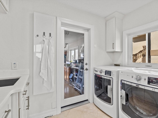 washroom featuring cabinets, light tile patterned flooring, washer and dryer, and sink