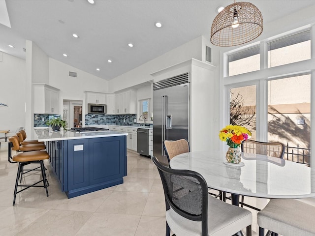 kitchen featuring pendant lighting, white cabinetry, stainless steel appliances, and plenty of natural light