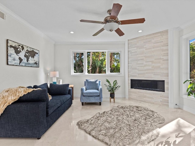 living room with crown molding, ceiling fan, and a fireplace