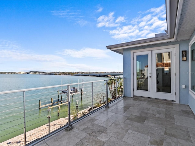 balcony featuring a water view and french doors