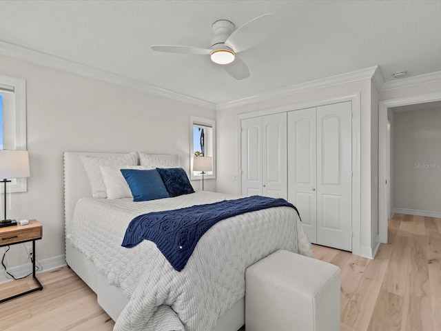 bedroom featuring crown molding, ceiling fan, light hardwood / wood-style floors, and a closet